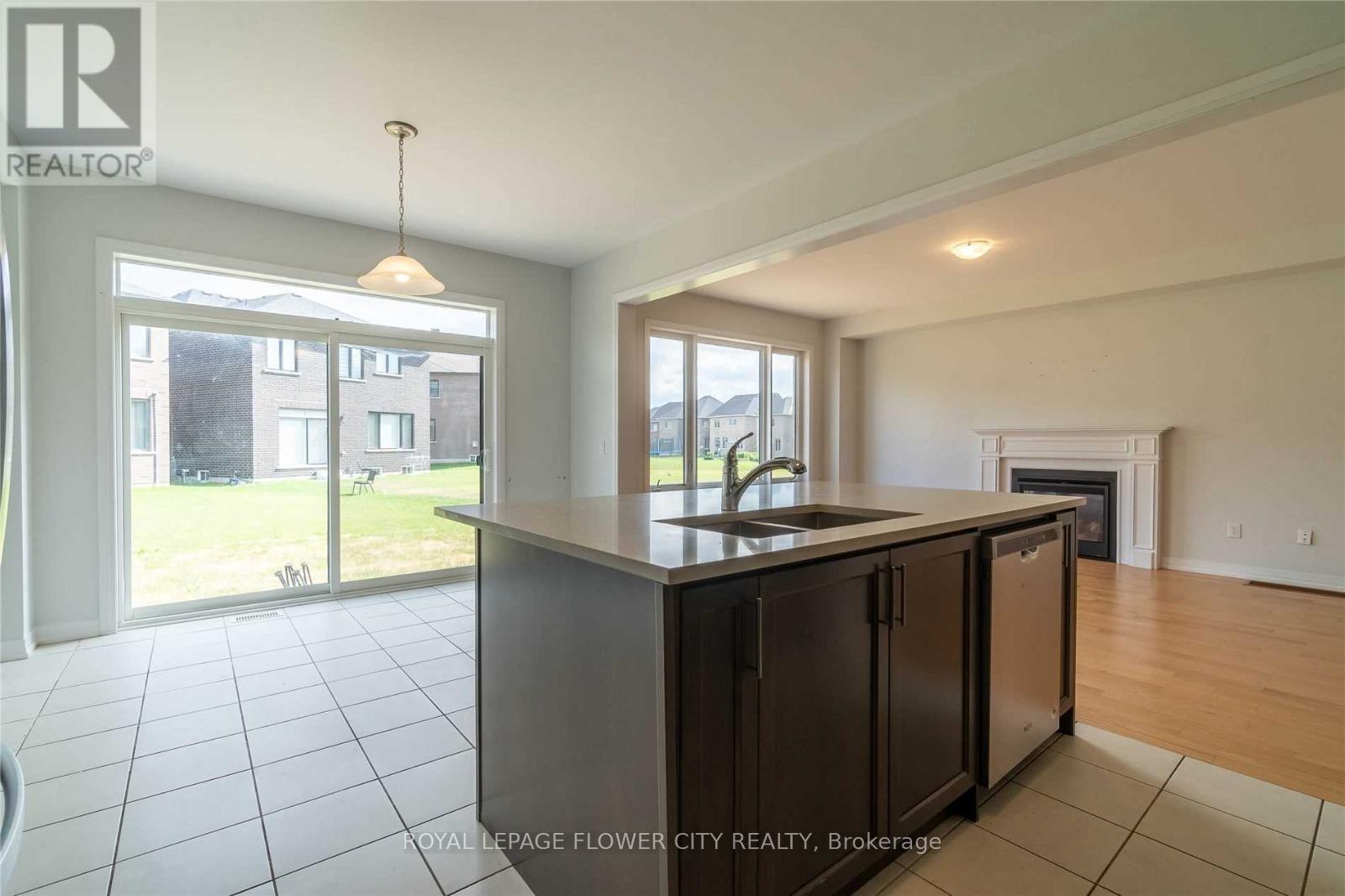A modern kitchen with a large island and a view of the backyard.
