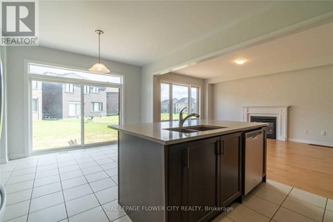 A modern kitchen with a large island and a view of the backyard.