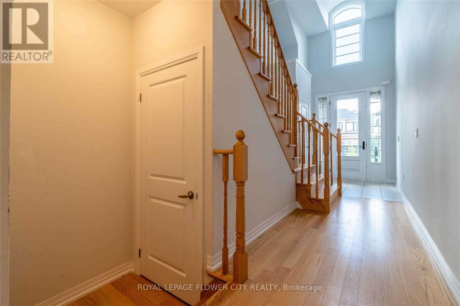 A hallway with a white door and wooden stairs.