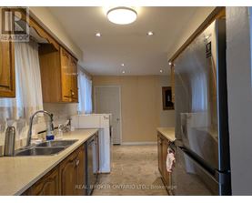 A kitchen with wooden cabinets and a stainless steel refrigerator.