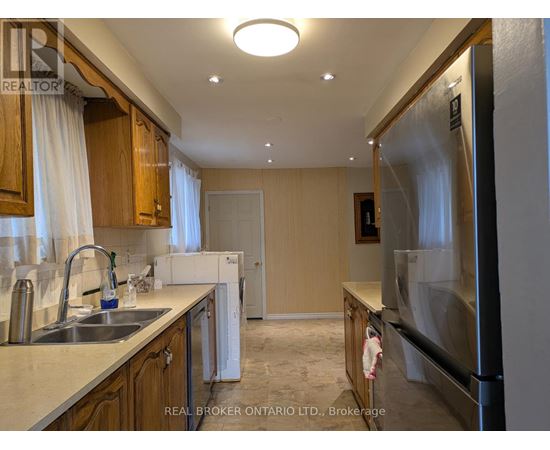 A kitchen with wooden cabinets and a stainless steel refrigerator.