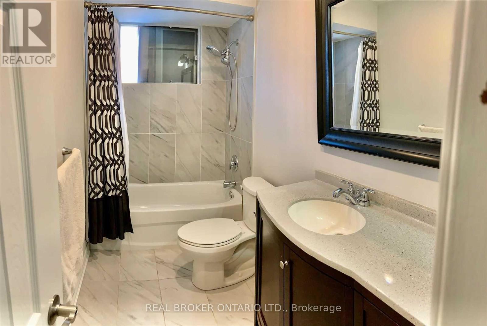 A bathroom with a toilet, sink, and bathtub.