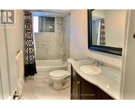 A bathroom with a toilet, sink, and bathtub.