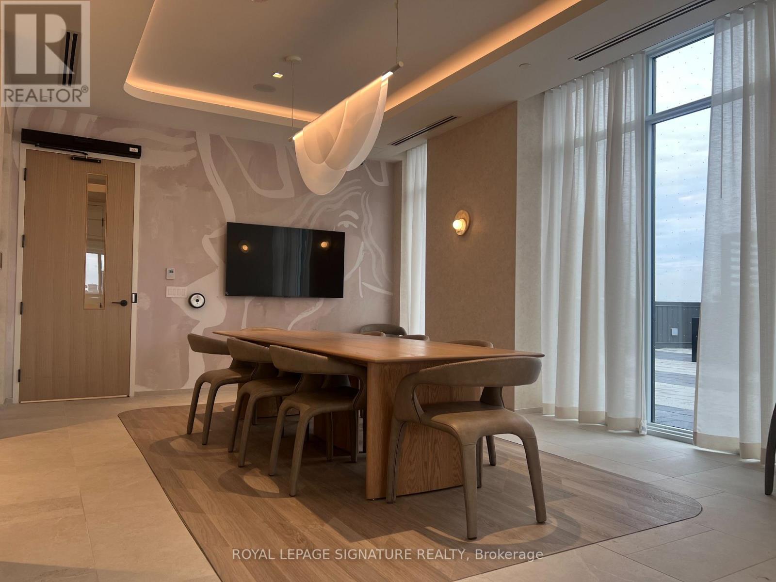A modern dining room with a wooden table and chairs.