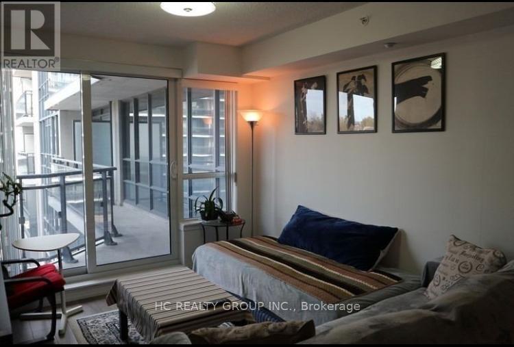 A bedroom with a bed, a chair, and pictures on the wall.