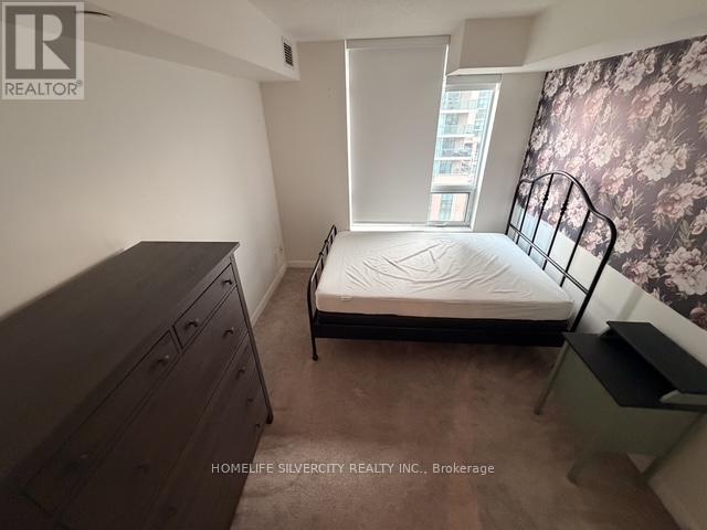 A bedroom with a bed, dresser, and window.