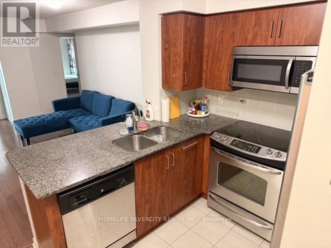 A kitchen with a blue sofa in the living room.