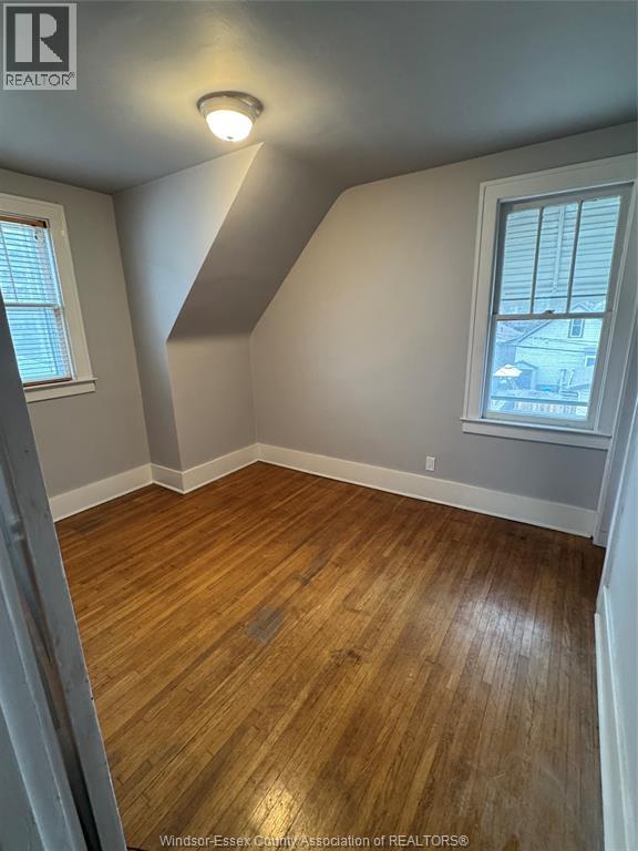 A room with wooden flooring and a window.