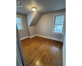 A room with wooden flooring and a window.