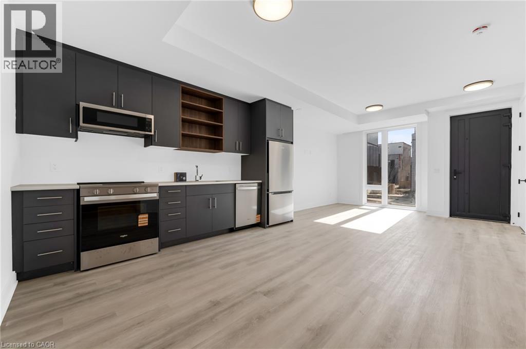 A modern kitchen with dark wood cabinets and a stainless steel oven.