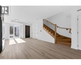 A spacious room with a staircase leading to the upper floor.