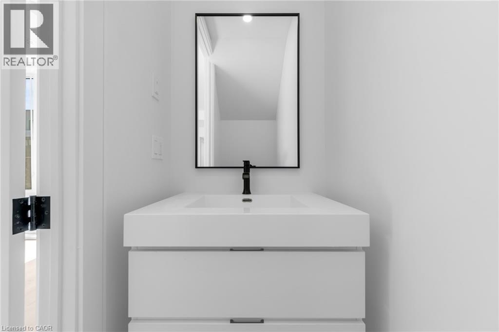 A white sink sits under a mirror in a bathroom.
