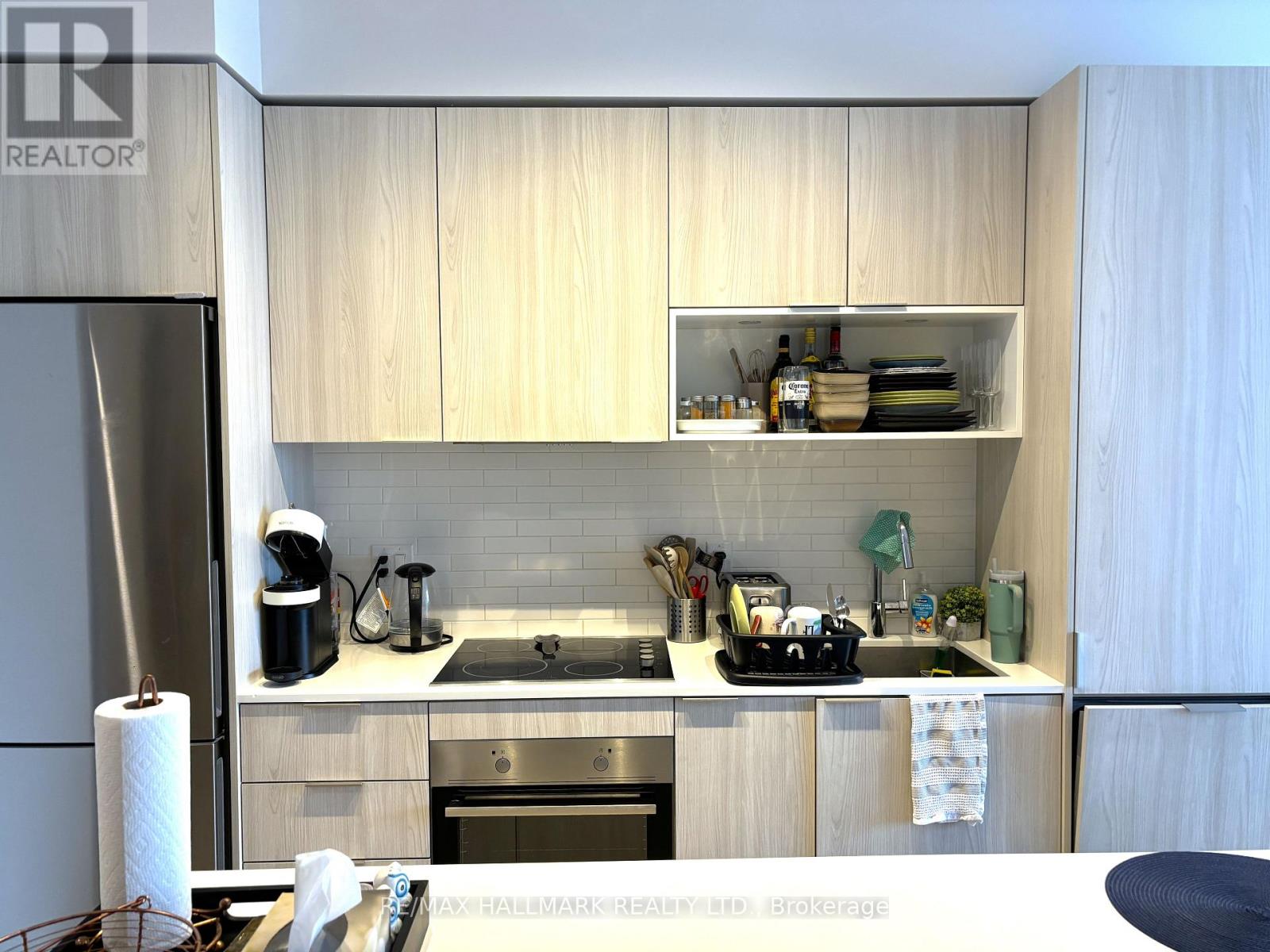 A kitchen with wooden cabinets and a white fridge.