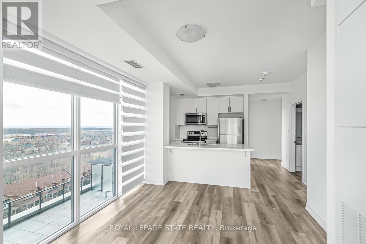 A spacious, well-lit room with a view of the cityscape outside the large windows.
