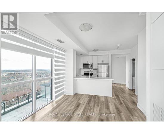 A spacious, well-lit room with a view of the cityscape outside the large windows.