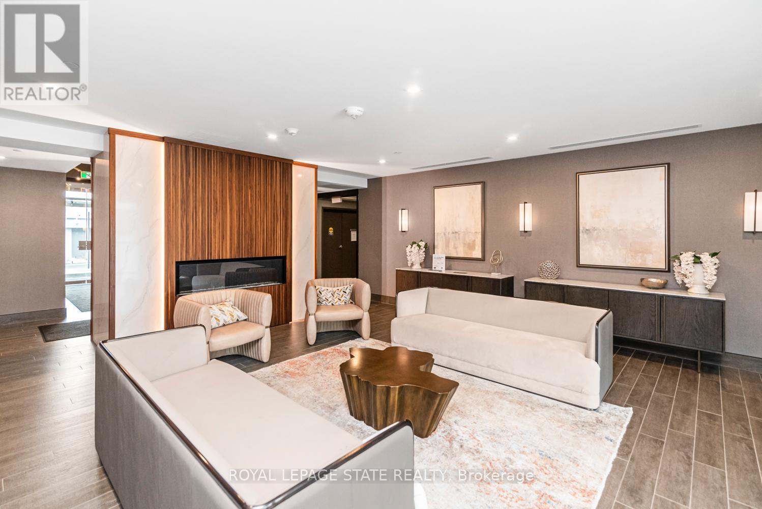 A living room with a white couch and a fireplace.