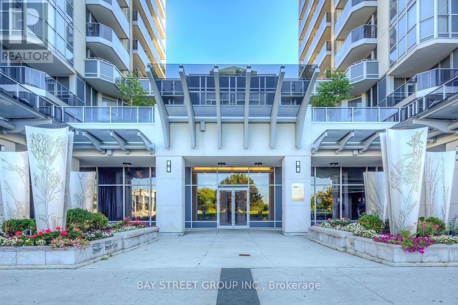 The Bay Street Group Inc. Brokerage building entrance is adorned with flowers and greenery.