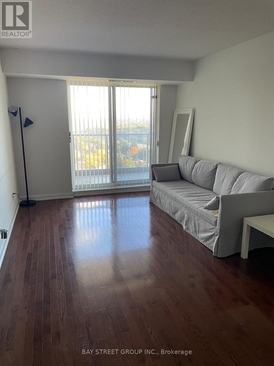 A living room with a grey couch and a wooden floor.