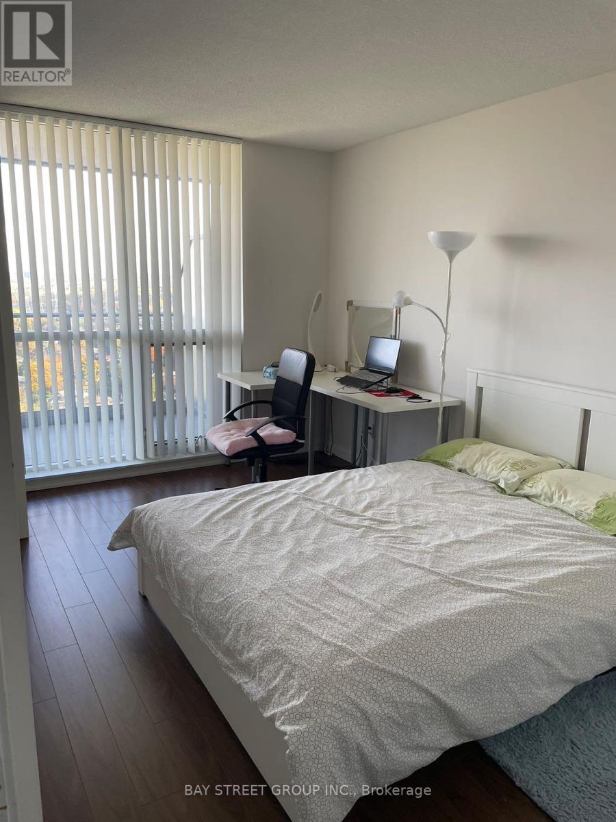 A bedroom with a bed, desk, and chair.