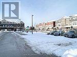 A snowy street with cars parked on the side.