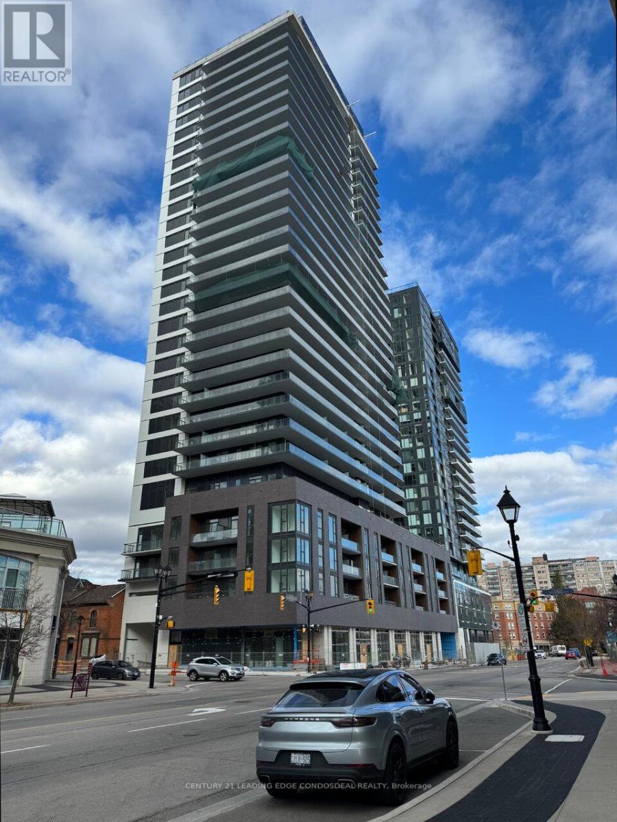 A tall building with many windows is in the background of a street scene.