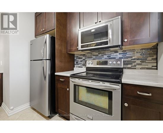 A modern kitchen with a stainless steel refrigerator and oven.