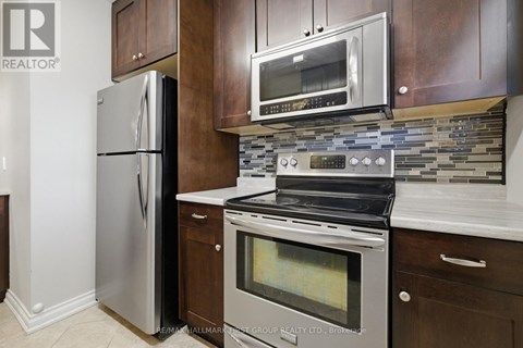 A modern kitchen with a stainless steel refrigerator and oven.