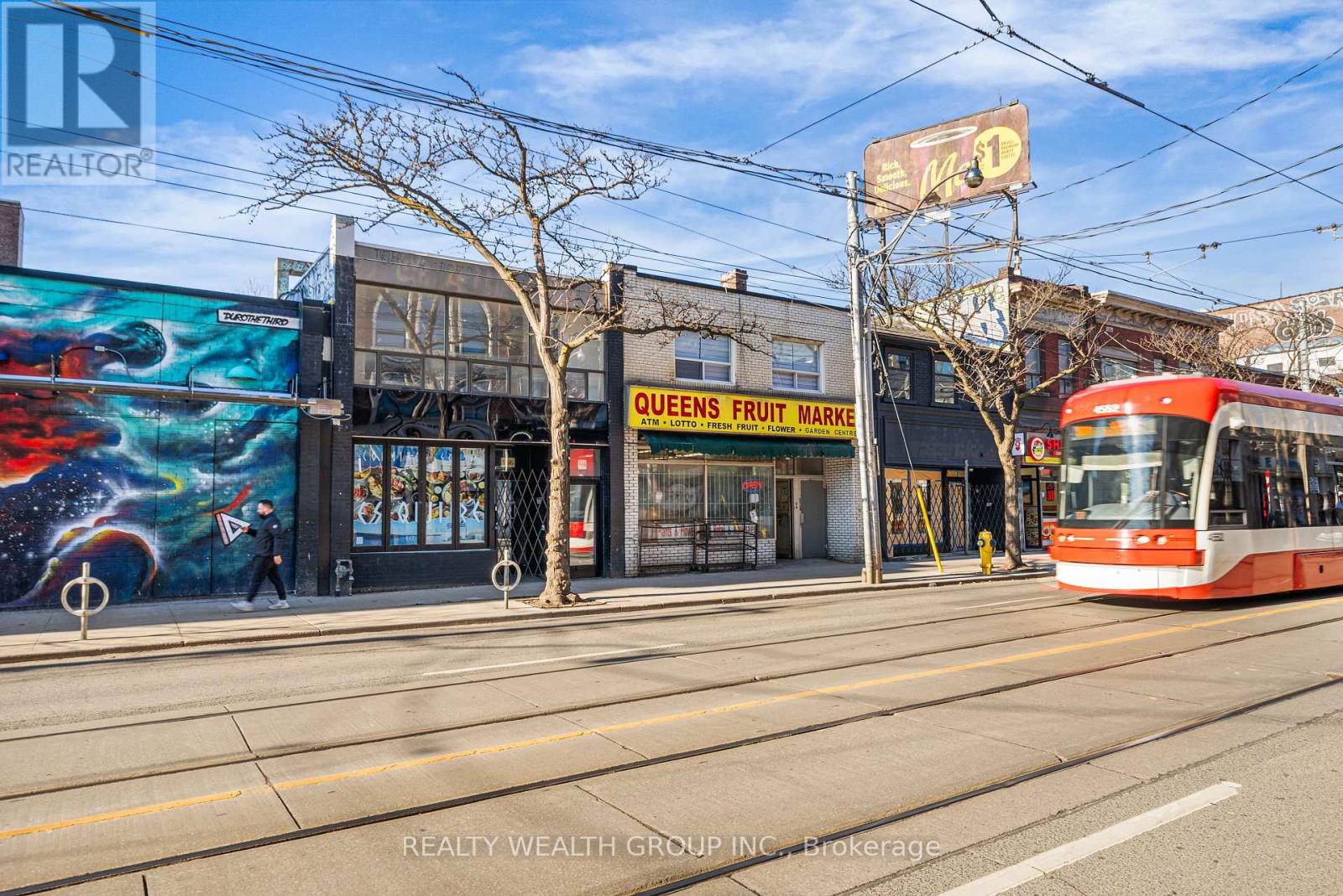 A street view with a bus and a fruit market.