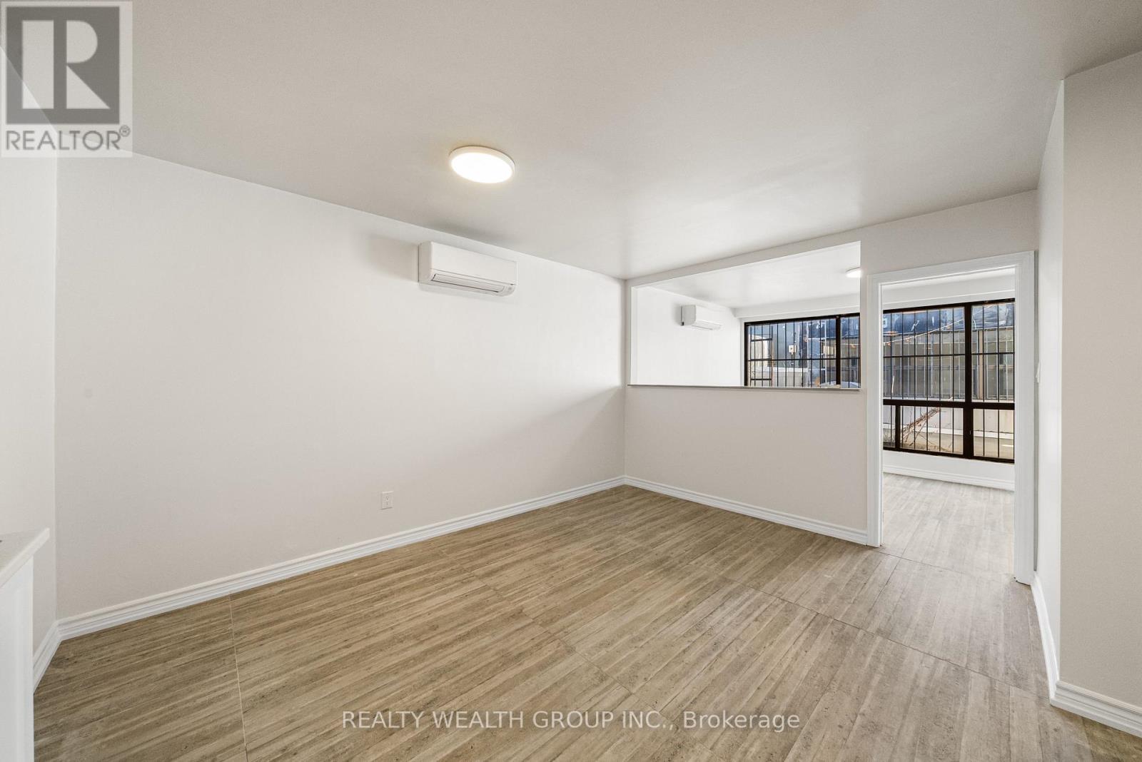 A room with a window and a door leading to a balcony.