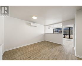 A room with a window and a door leading to a balcony.