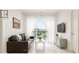 A living room with a brown couch, a white coffee table, and a flat screen TV mounted on the wall.