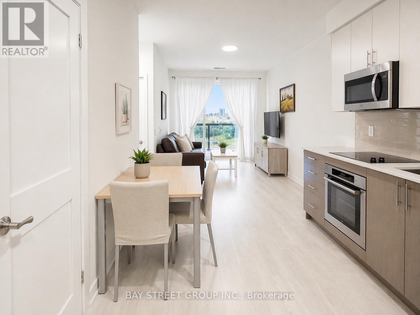 A modern kitchen and dining area with a view of the city.