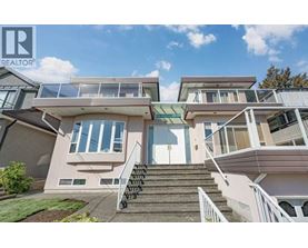 A modern house with a glass balcony and stairs leading to the entrance.