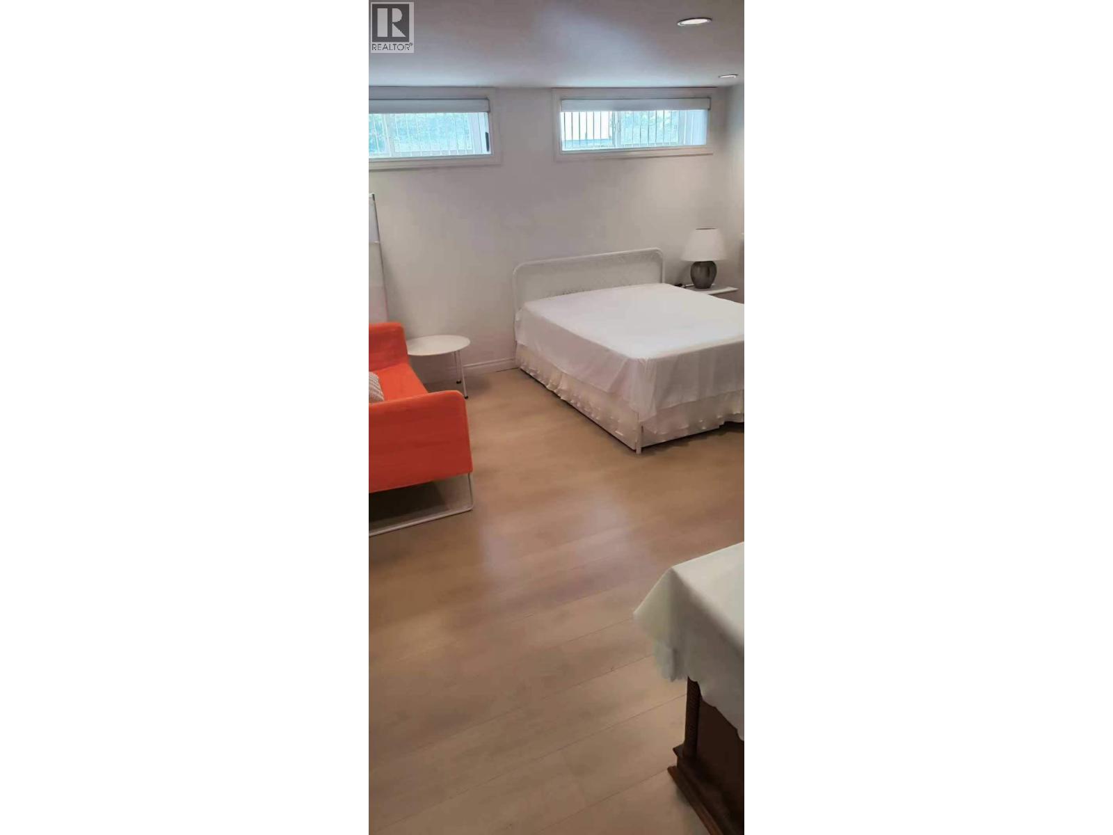 A bedroom with a bed, a chair, and a table.