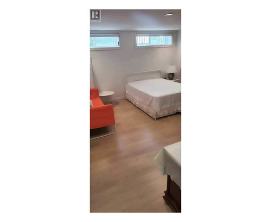 A bedroom with a bed, a chair, and a table.
