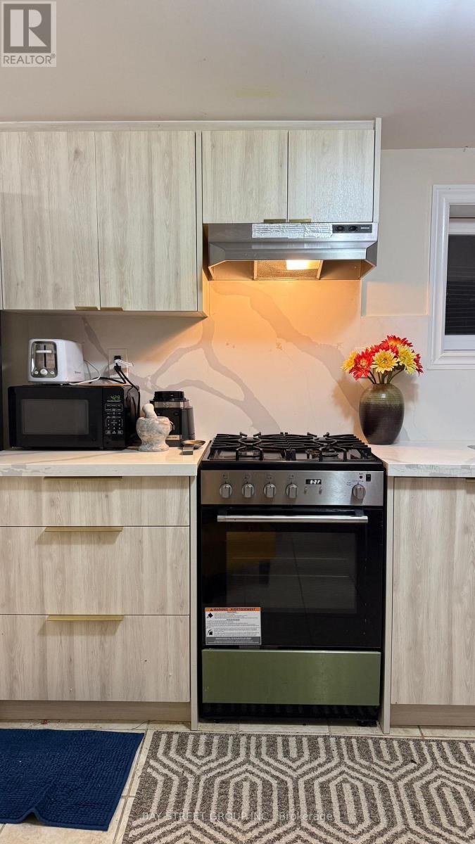 A modern kitchen with a black stove top oven and a microwave on the counter.