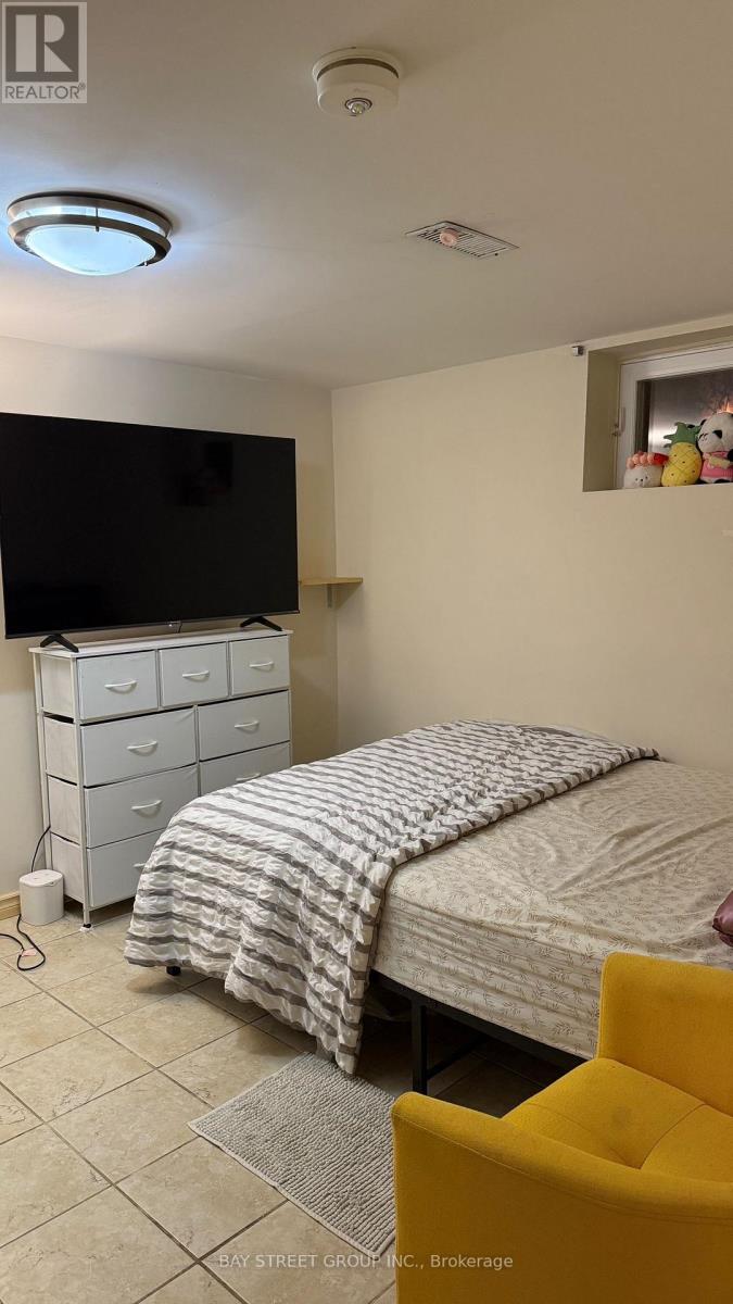 A bedroom with a bed, dresser, and television.