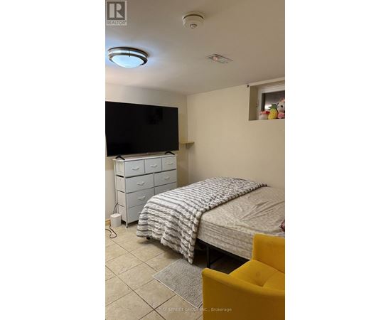 A bedroom with a bed, dresser, and television.