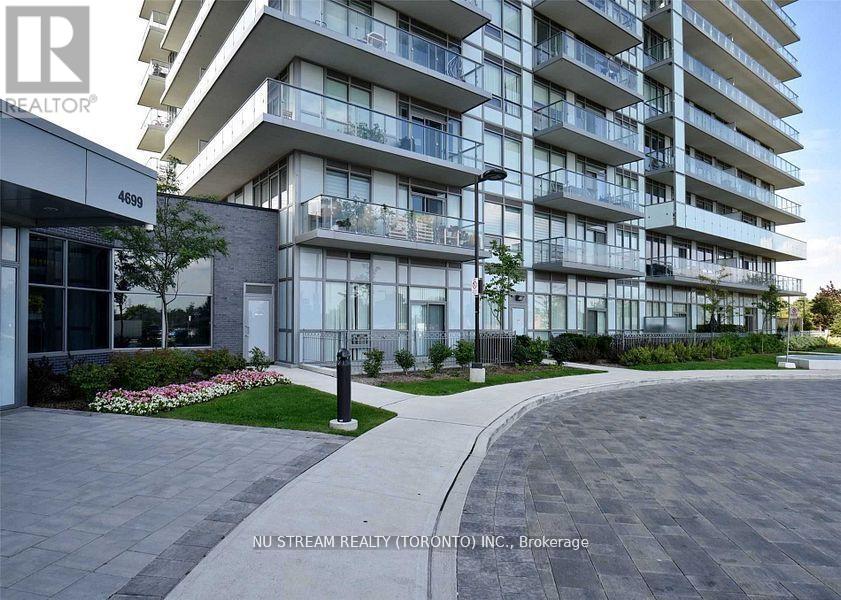A modern apartment building with a well-maintained lawn in front.