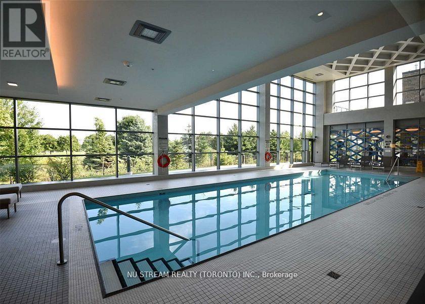 A large indoor swimming pool with a glass wall on one side.