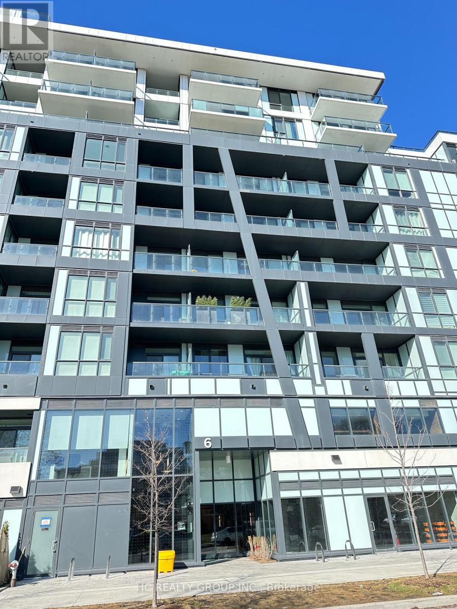 A modern multi-story building with balconies and glass windows.