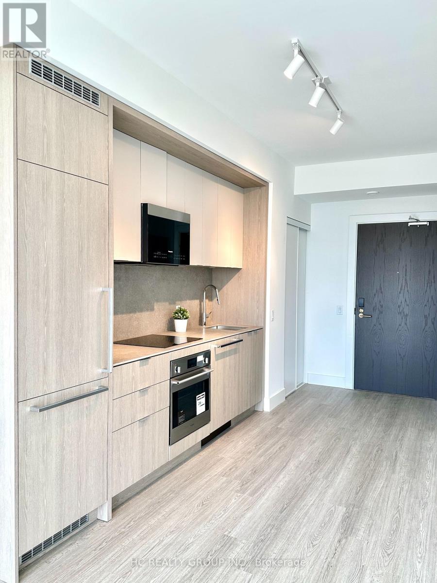 A modern kitchen with wooden cabinets and a black oven.