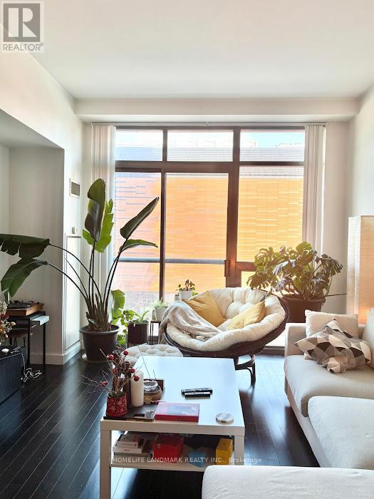 A living room with a white couch, a coffee table, and a large window.
