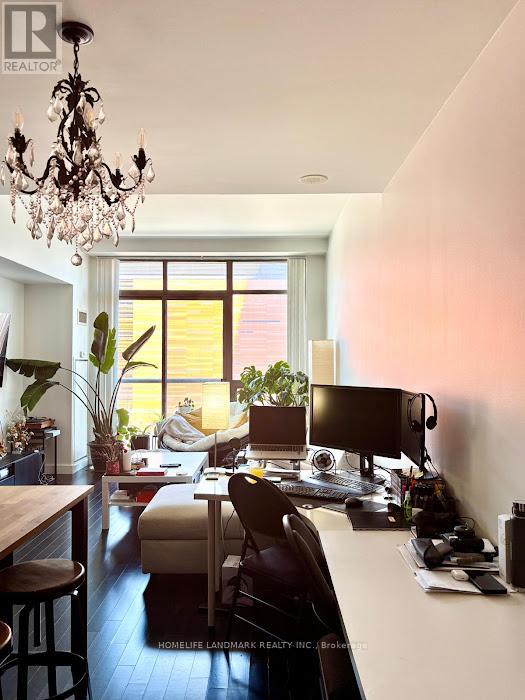 A well-lit home office with a desk, chair, and computer setup.