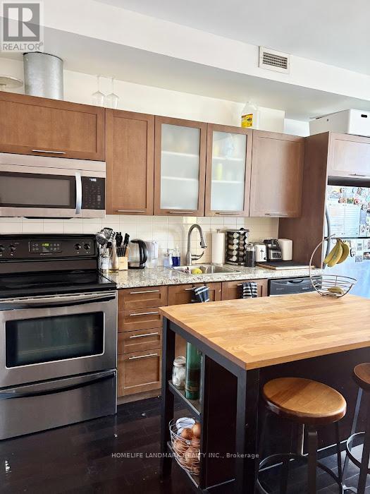 A kitchen with a wooden counter top and stainless steel appliances.