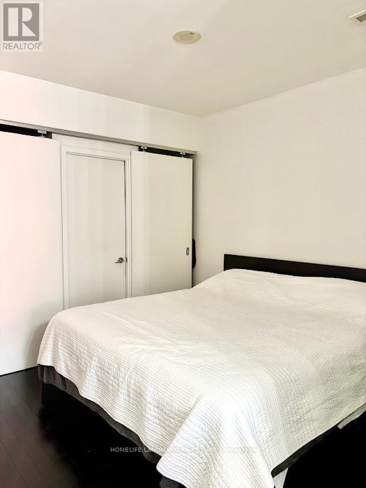A bedroom with a bed, a door, and a window.