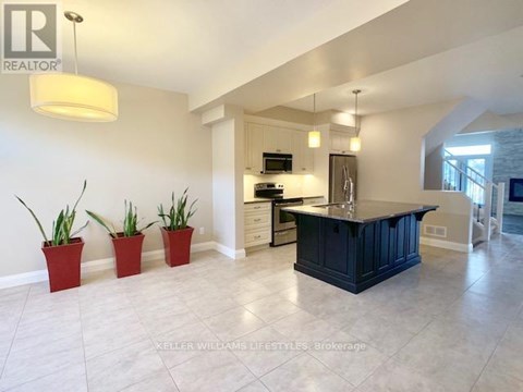 A kitchen with a black counter and three red pots.