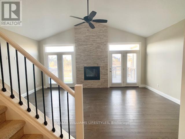 A living room with a fireplace and a staircase.