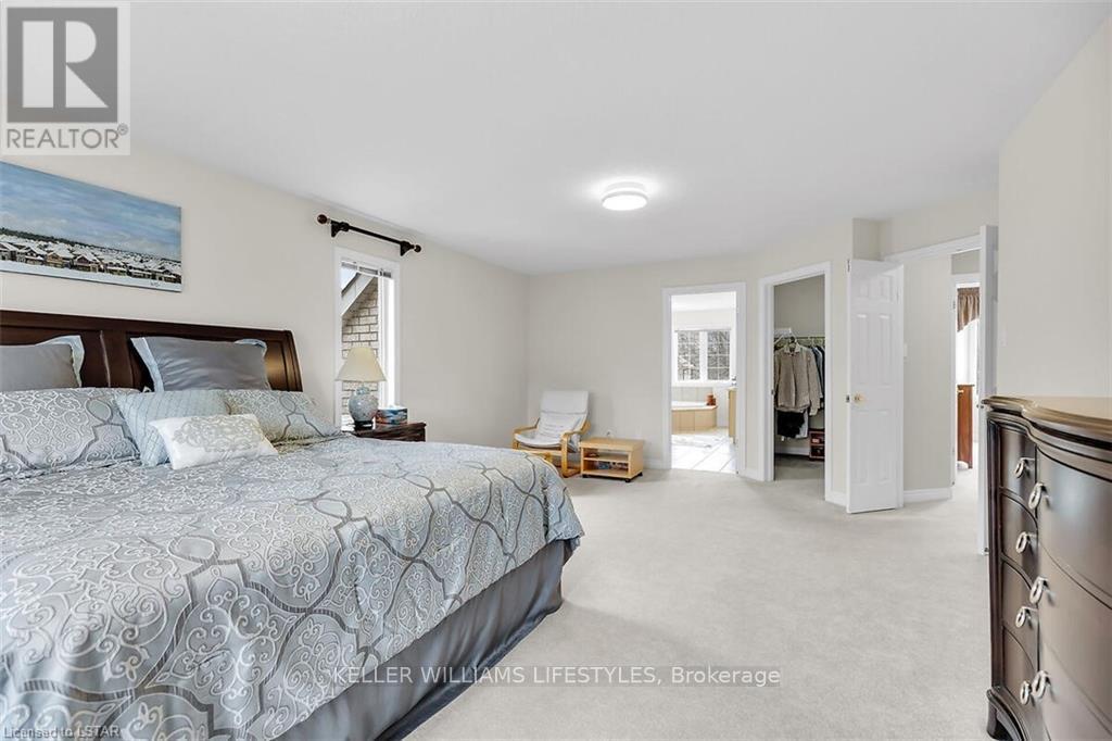 A bedroom with a large bed and a painting on the wall.