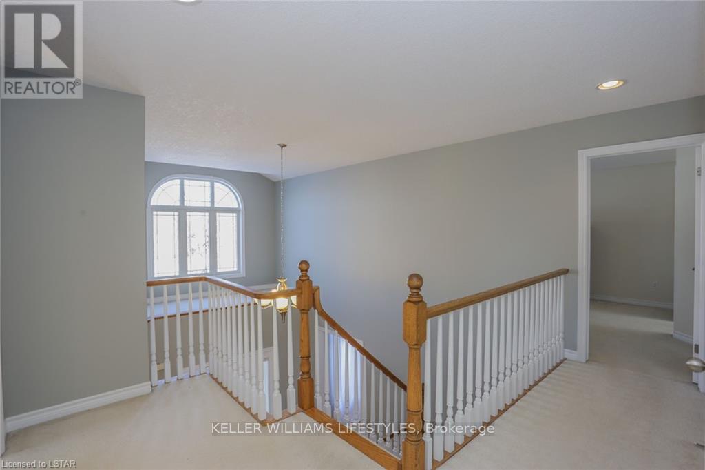 A spacious room with a staircase leading to the second floor.